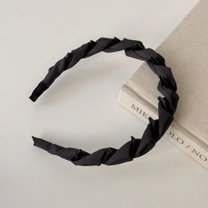 Detail of black woven satin headband with non-slip teeth for secure and elegant hair styling