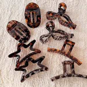 Retro tortoiseshell leopard print hair claw clips in various shapes on beige fabric
