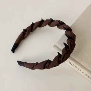 Close-up of twisted brown satin headband with anti-slip teeth and fabric texture