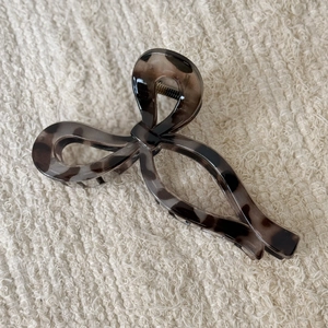 Close-up of tortoise shell leopard print hair claw clip with vintage bow design