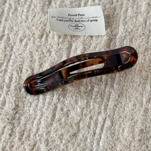 Détail d'une pince à cheveux vintage française avec motif léopard sur tissu doux