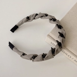 Detail of grey fabric headband with black geometric patterns and non-slip ends