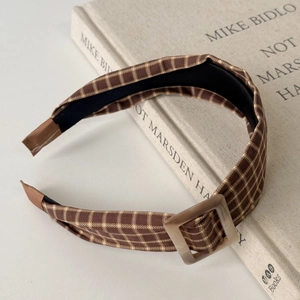 Detail of vintage plaid headband with brown resin buckle and non-slip inner lining