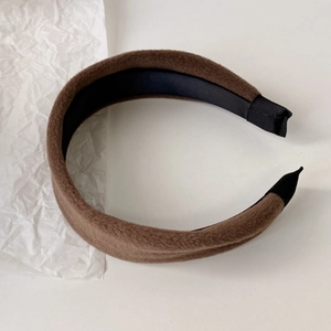 Detail view of the brown plush headband with soft fabric texture and black ribbon ends