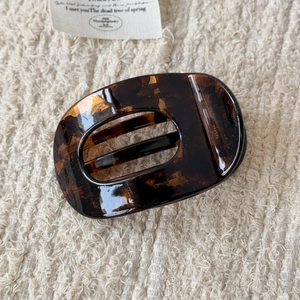 Détail du motif écaille de tortue ambré sur une pince à cheveux ovale brillante