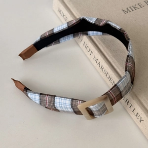 Detail of retro plaid headband with square buckle and vintage college style texture