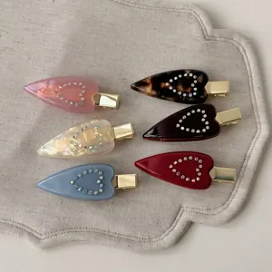 Six-piece set of heart-shaped acetate hair clips with rhinestones in various colors
