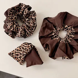 Leopard print and solid brown scrunchies hair accessories set on white background