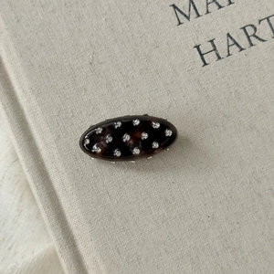 Détail macro d'une barrette ovale en écaille de tortue sertie de strass brillants