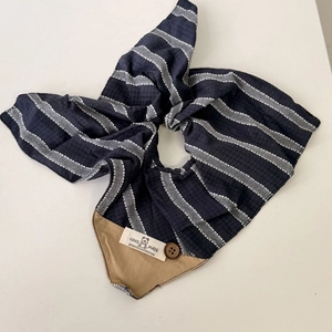 Dettaglio bandana in seersucker a righe blu con bottone in legno ed etichetta a mano