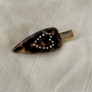 Detail of tortoise shell heart hair clip with sparkling rhinestones and gold metal base