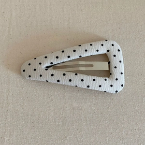 Chic vintage triangle BB hair clip with black polka dot fabric on a minimalist background