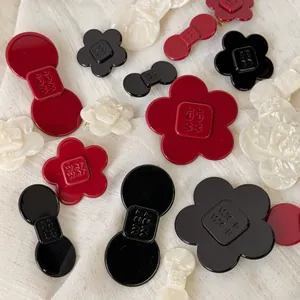 Macro detail of acetic acid hair clips featuring flower shapes and wer wer engraving