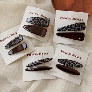 Vintage leopard and brown hair clip set with acetate finish on cream linen background