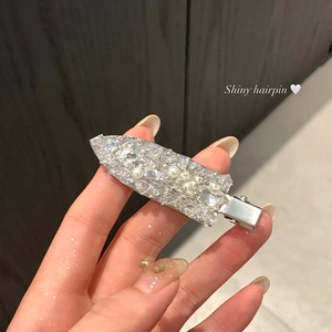 Close-up of shiny silver hairpin with rhinestones and white pearls in macro view