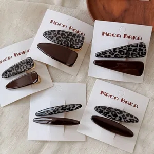 Close-up of leopard print and dark brown resin hair clips on a white display card