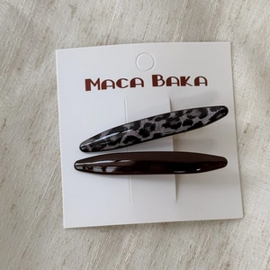 Close-up of leopard print and dark brown resin hair clips set on a display card