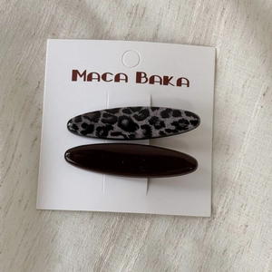 Detail of leopard print and dark brown resin hair clips on a white display card
