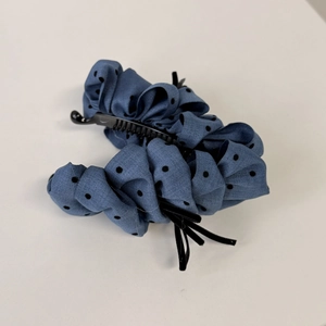 Detailed view of dark blue polka dot fabric banana clip with non-slip plastic comb teeth
