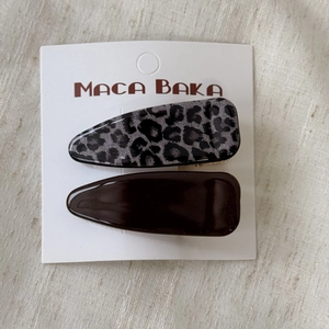 Detail of leopard print and dark brown resin hair clips set on white card packaging