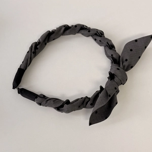 Detailed view of the vintage polka dot headband with non-slip teeth and fabric bow