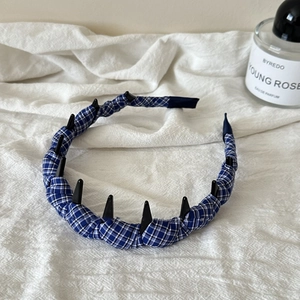 Dettaglio del cerchietto a scacchi bianchi e blu con denti neri interni antiscivolo