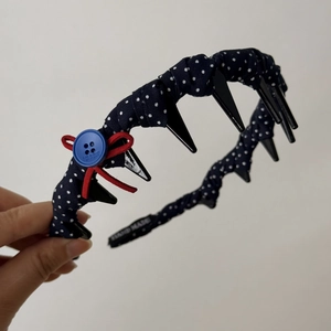 Detailed view of navy blue polka dot headband with red velvet bow and anti-slip teeth