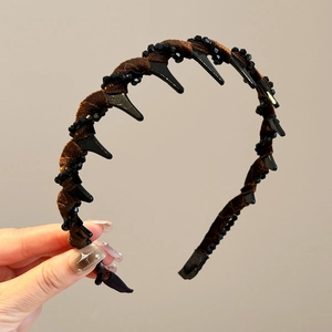 Detail of dark brown velvet headband with comb teeth and faceted black bead accents
