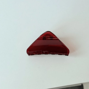 Detailansicht einer lichtdurchlässigen dunkelroten Haarklammer mit glänzendem Finish