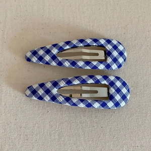 Detail of blue and white gingham fabric snap clips with metallic internal structure