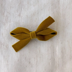 Ginger yellow velvet bow hair clip with vintage Korean style on a soft fabric background
