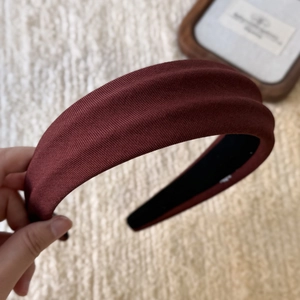 Detailed side view of thick padded sponge headband in deep burgundy textured fabric