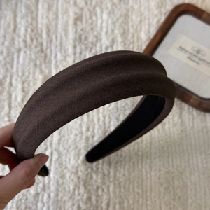 Detail of wide thick dark brown headband with textured knit fabric and padded foam