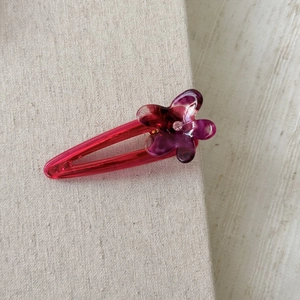 Detail of floral acetate hair clip with vibrant plum and pink resin petal texture