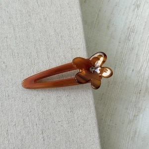 Macro shot of tortoiseshell acetate flower hair clip with a center rhinestone detail