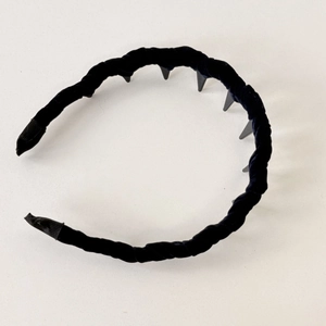 Detail view of the twisted black velvet headband featuring anti-slip inner plastic teeth