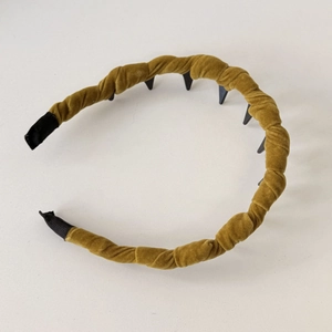 Detail view of mustard velvet headband featuring twisted texture and anti-slip inner teeth