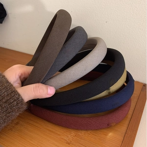 Stack of ribbed padded headbands in various colors like brown, grey, and navy blue