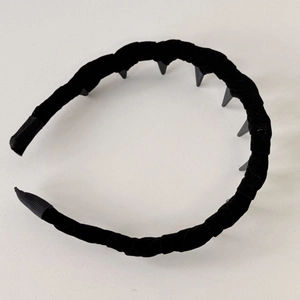 Detail view of the velvet hairband featuring non-slip teeth and pleated fabric texture