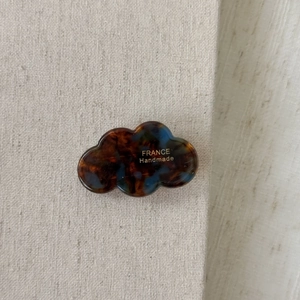 Detailed macro view of acetate cloud hair clip with brown and blue tortoiseshell pattern