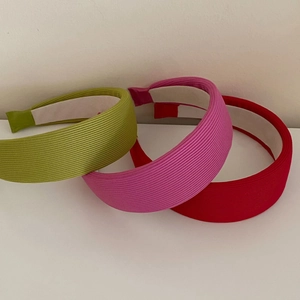 Three-piece set of vibrant padded knit headbands in neon green, pink, and bold red colors