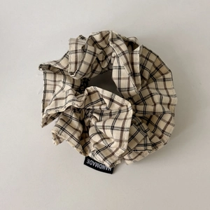 Classic beige checkered fabric scrunchie with a black handmade woven label tag