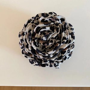 Close-up of leopard print fabric rose on hair claw clip with elegant retro flower detail
