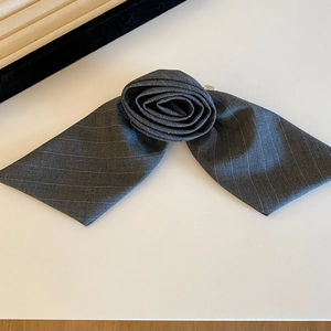 Detail of grey striped suiting fabric hair accessory in a delicate flower bow shape