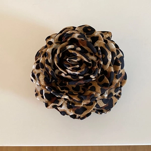 Detail of elegant 3D rose hair claw clip featuring classic leopard print pattern