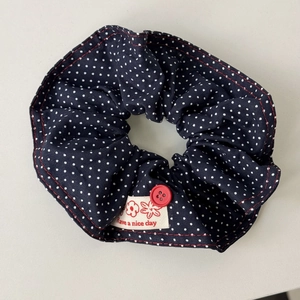 Navy blue polka dot scrunchie with red button detail and Have a nice day label