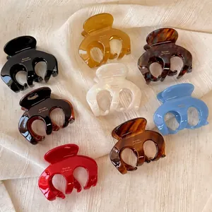 Set of eight colorful acetate octopus hair claws in various glossy finishes on fabric