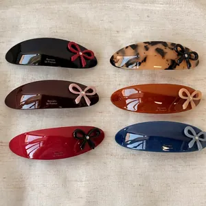 Six-piece set of elegant acetate hair barrettes with rhinestone bows and gold lettering