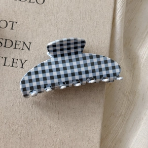 Detail view of the checkered acetic acid hair claw clip with sturdy white gripping teeth