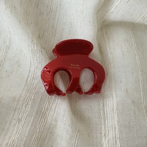 Detail view of red acetate hair claw with golden Barrette La France lettering text